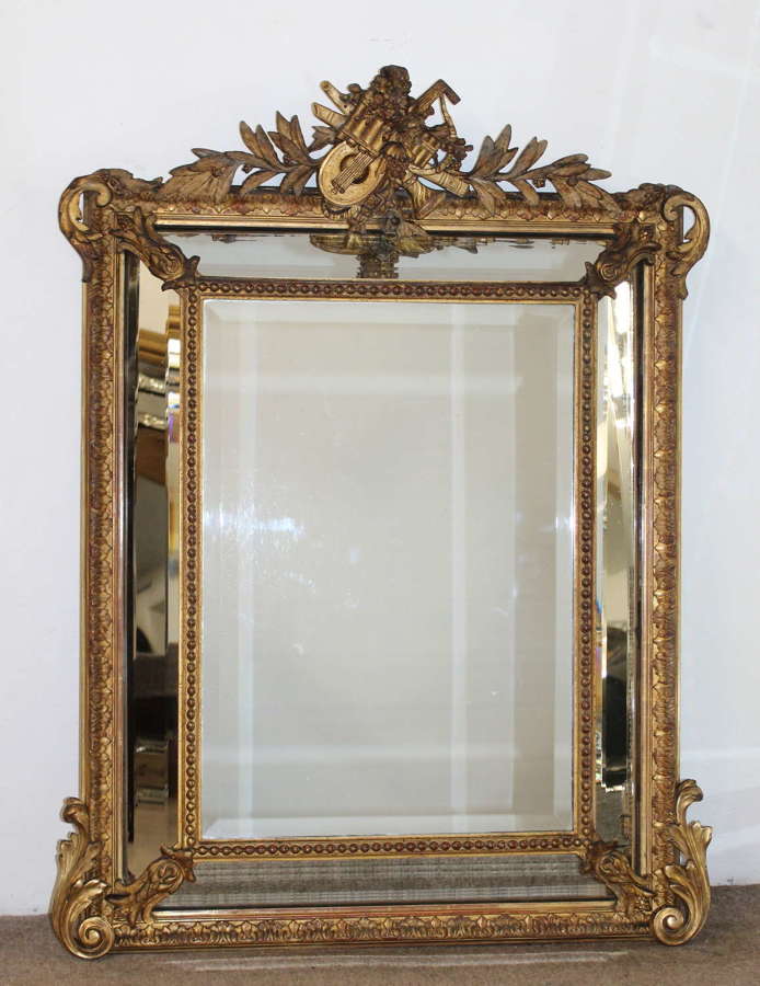 Antique French gilt cushioned mirror with musical instruments