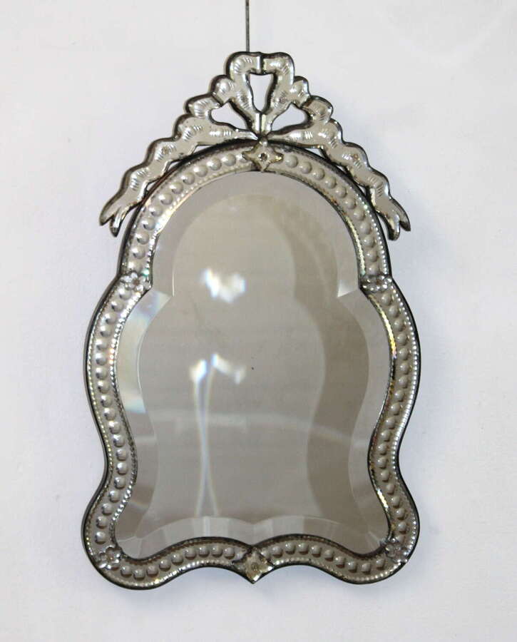 Small antique curvy Venetian mirror with bow