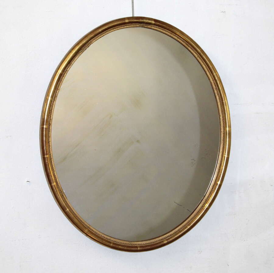 Antique French oval mirror with narrow gilt frame